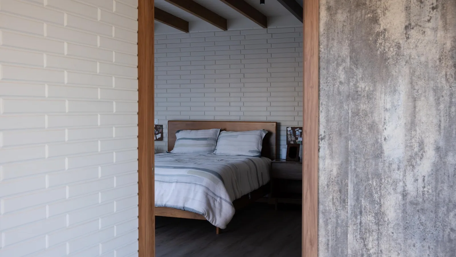 Calm bedroom with white block walls and a timber bed