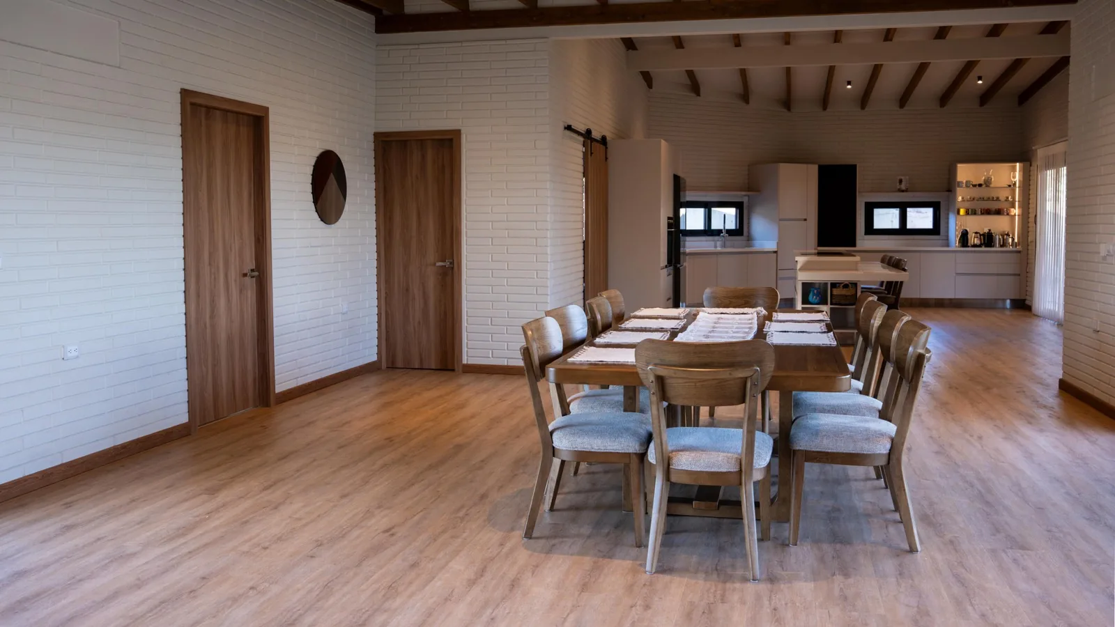 Spacious dining room with a long timber table and white block walls