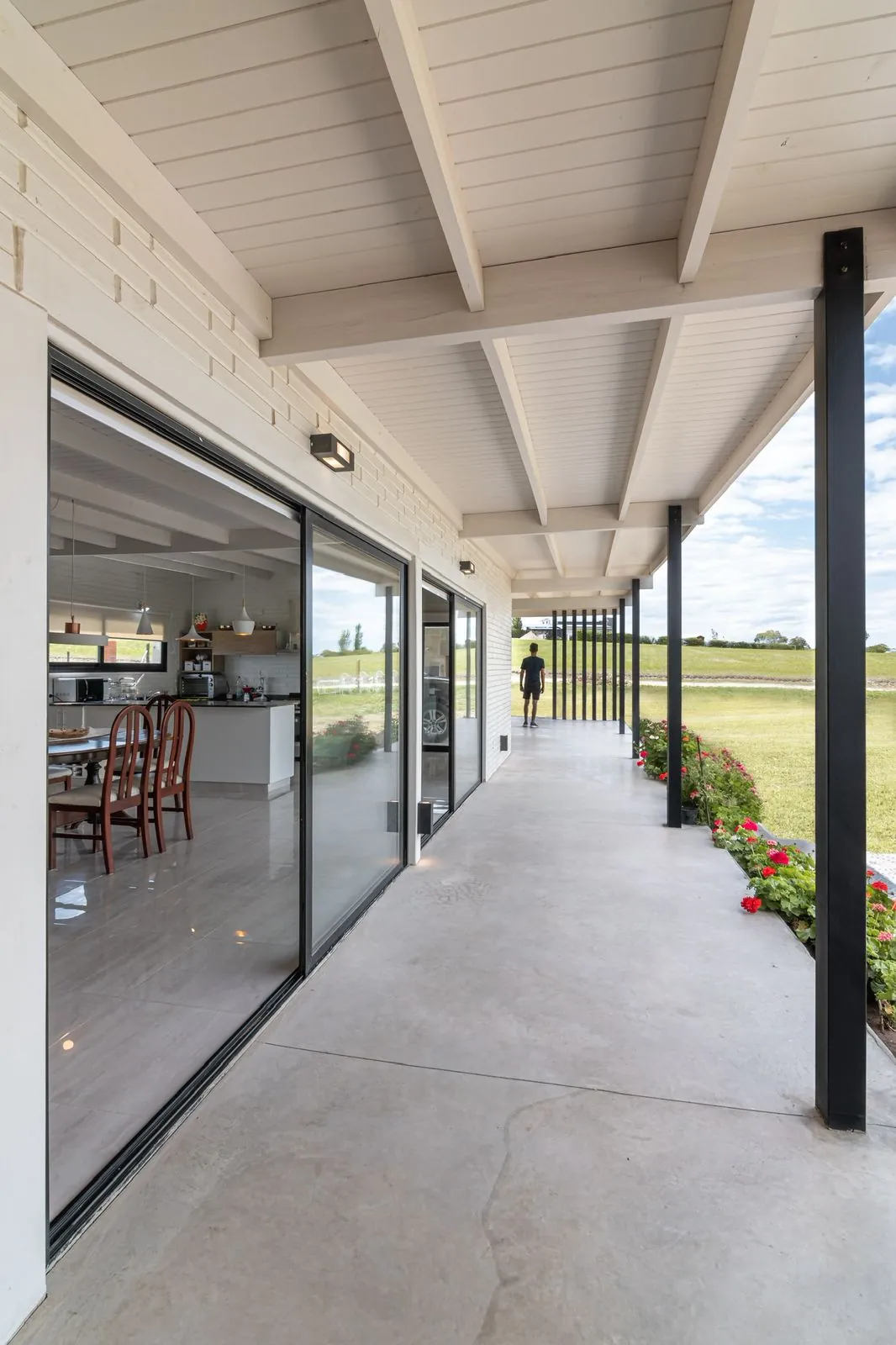 Long covered patio corridor with black posts