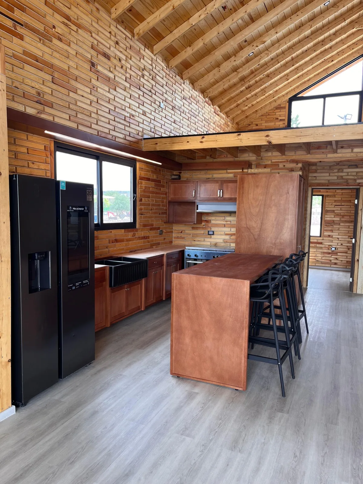 Warm natural wood kitchen with island and bar stools